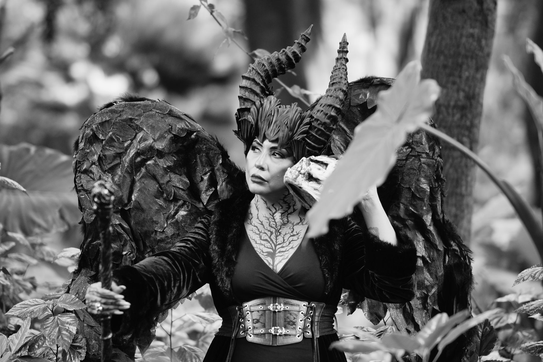 A dramatic portrayal of a fantasy character with horns in a mystical forest setting.